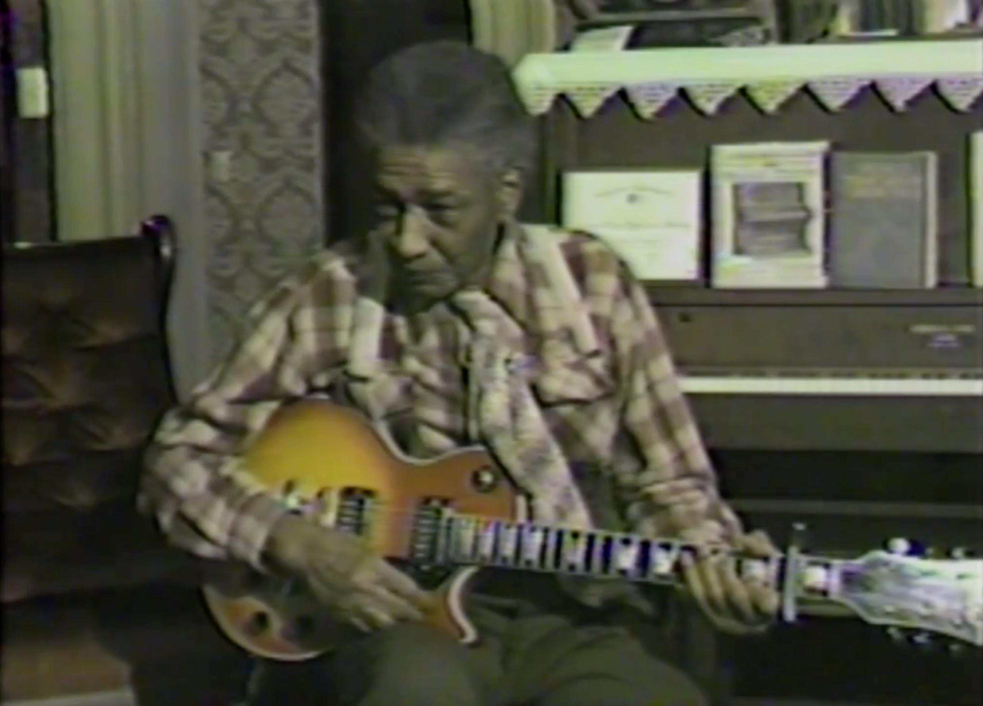 Eddie Bowles playing guitar during an interview